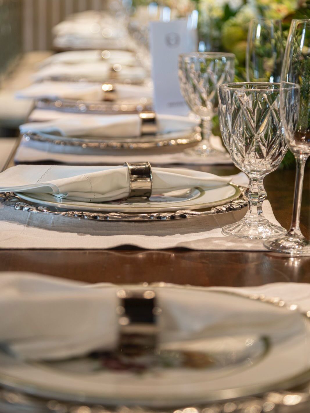 Detalhe de mesa posta com taças de cristal e guardanapo de linho